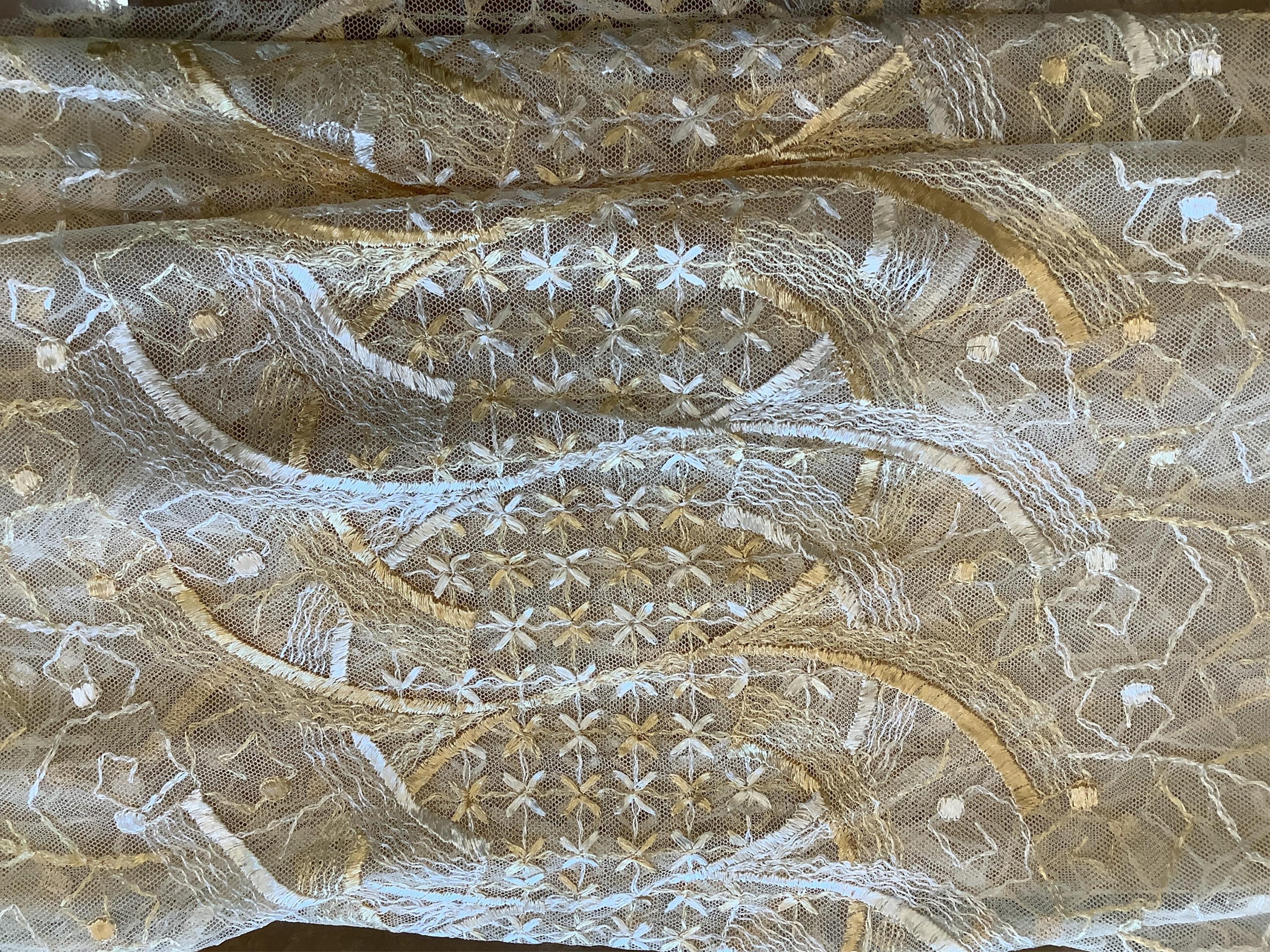 A French Art Deco wide silk yellow and cream embroidered net curtain, bordered at the bottom with yellow silk fringing. Approximately 560cm wide x 170cm long (not including fringing)., Condition - the curtain may need re